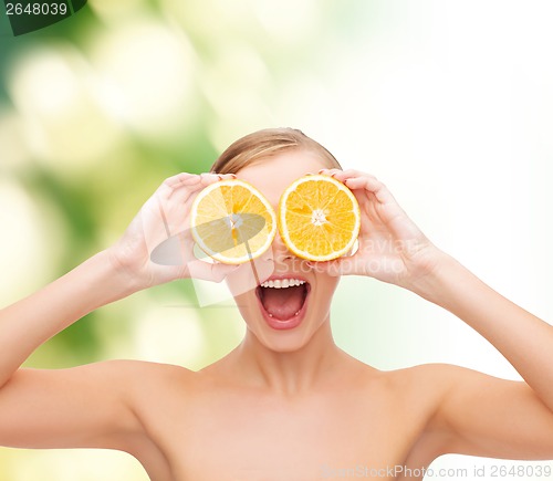 Image of amazed young woman with orange slices