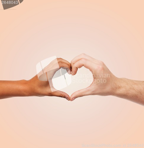 Image of woman and man hands showing heart shape