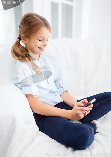 Image of smiling girl with smartphone at home