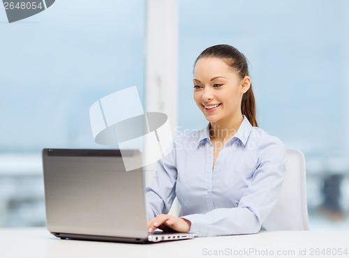 Image of businesswoman with laptop in office