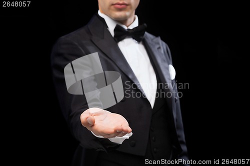 Image of magician holding something on palm of his hand