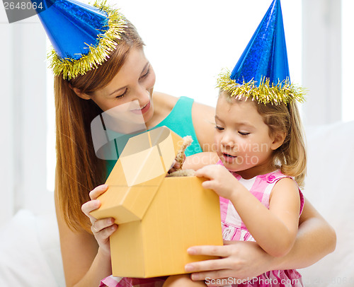 Image of mother and daughter in blue hats with favor horns