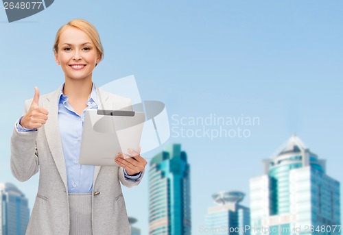 Image of smiling woman with tablet pc showing thumbs up