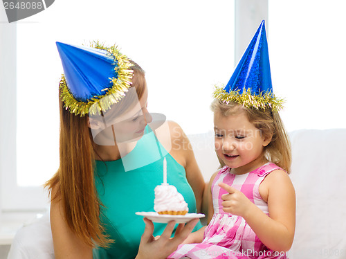 Image of mother and daughter in blue hats with cake
