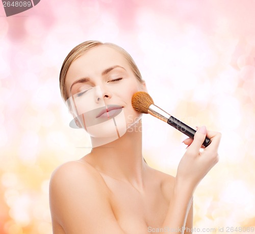 Image of beautiful woman with makeup brush