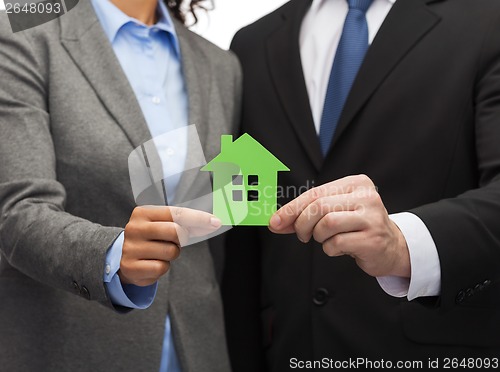 Image of businessman and businesswoman holding green house