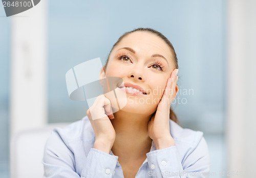 Image of smiling businesswoman dreaming in office