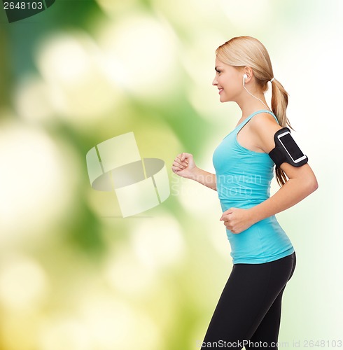 Image of sporty woman running with smartphone and earphones