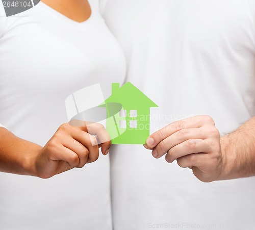 Image of couple hands holding green house