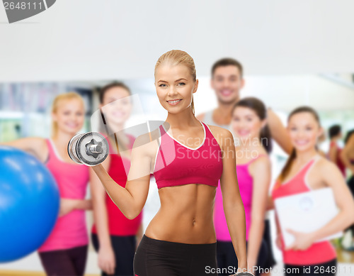 Image of smiling woman with heavy steel dumbbells