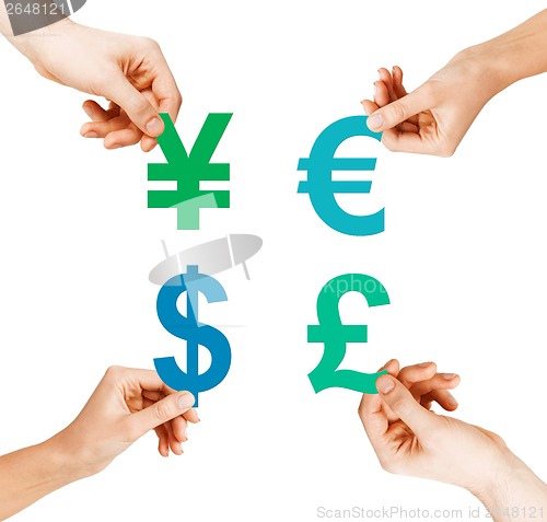 Image of four hands holding currency symbols