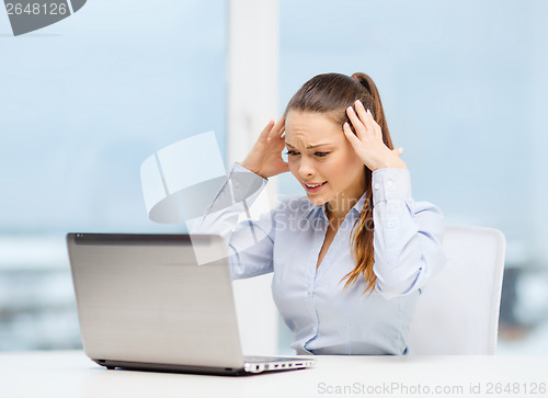 Image of stressed woman with laptop