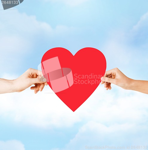 Image of couple hands holding red heart