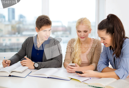 Image of smiling students with notebooks at school