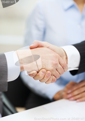 Image of two businessmen shaking hands in office