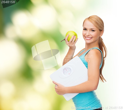 Image of sporty woman with scale and green apple