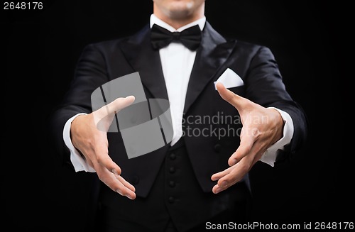 Image of magician in top hat showing trick