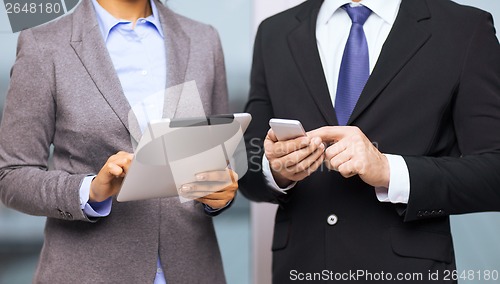 Image of two businesspeople with smartphone and tablet pc