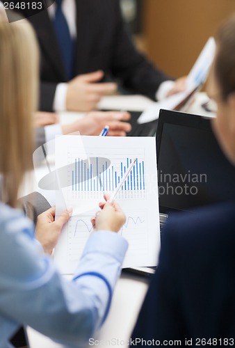 Image of close up of chats, laptop and graphs in office