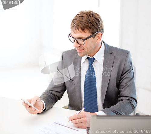 Image of businessman working with laptop and smartphone