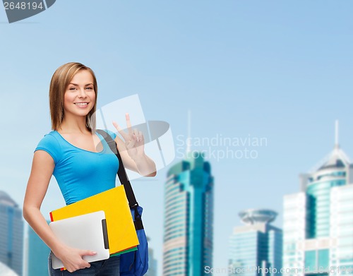 Image of female student with bag, tablet pc and folders