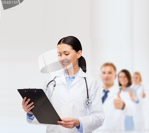 Image of smiling female doctor with clipboard