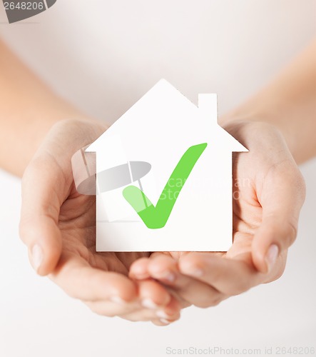 Image of hands holding house with check mark