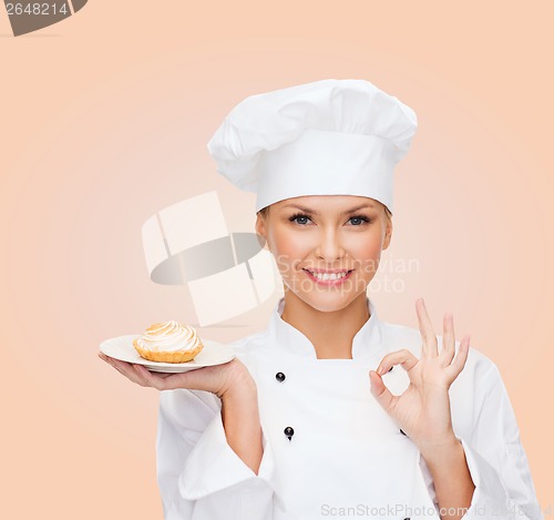 Image of smiling female chef with cake on plate