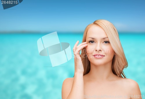 Image of beautiful woman touching her eye area
