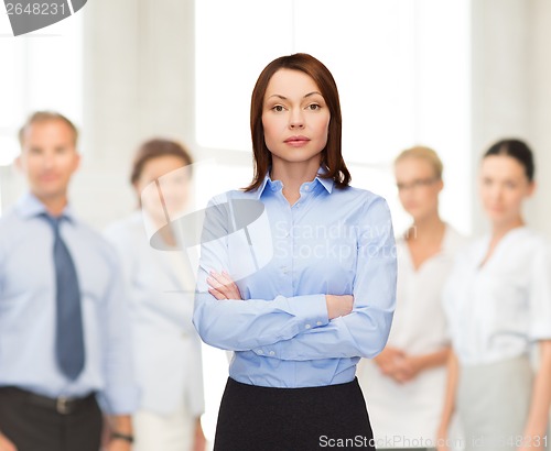 Image of smiling businesswoman with crossed arms at office