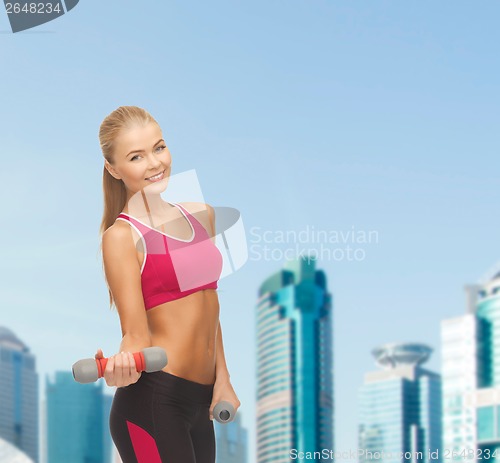 Image of young sporty woman with light dumbbells