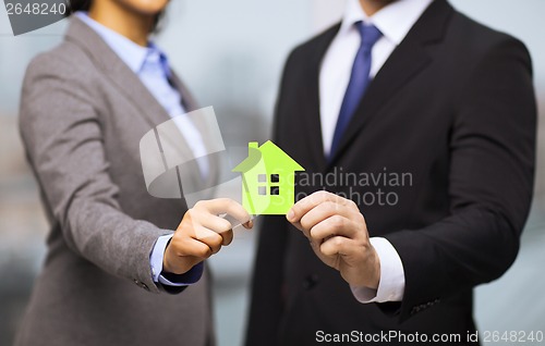 Image of businessman and businesswoman holding green house
