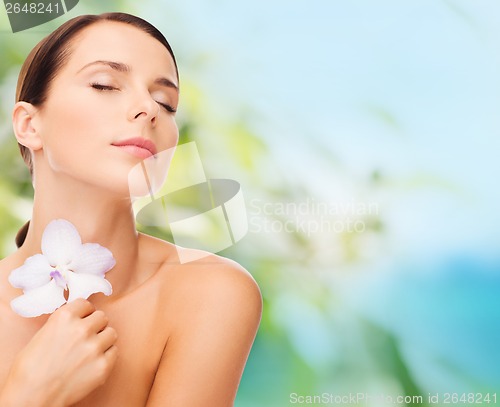 Image of relaxed woman with orhid flower