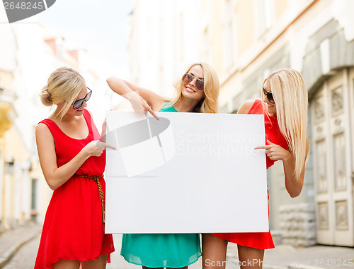 Image of three happy blonde women with blank white board