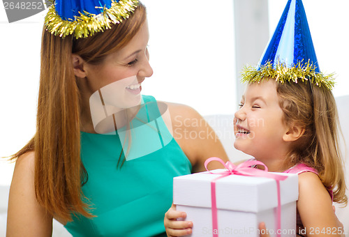 Image of mother and daughter in blue hats with favor horns