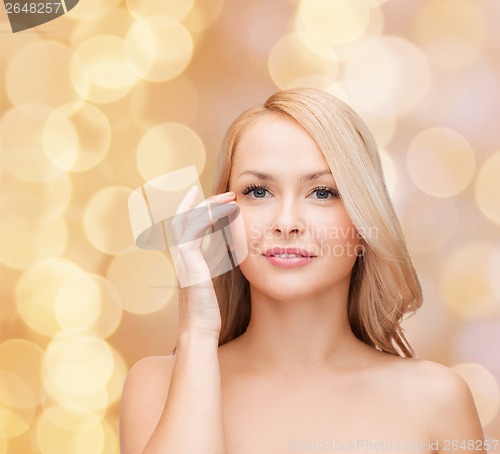 Image of beautiful woman touching her eye area