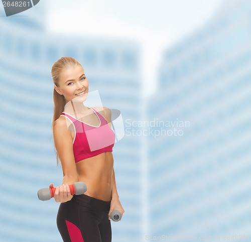 Image of young sporty woman with light dumbbells