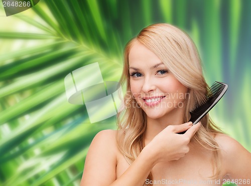 Image of smiling woman with hair brush