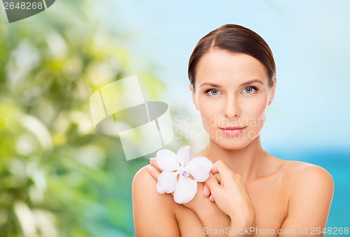 Image of relaxed woman with orhid flower