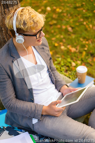 Image of smiling male student in eyeglasses with tablet pc