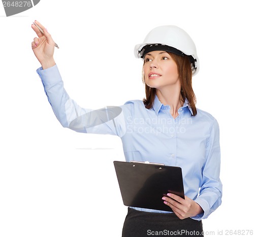 Image of smiling businesswoman in helmet with clipboard