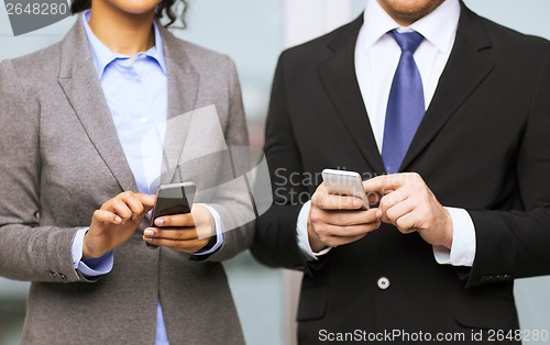 Image of businessman and businesswoman with smartphones