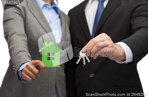 Image of businessman and businesswoman holding green house