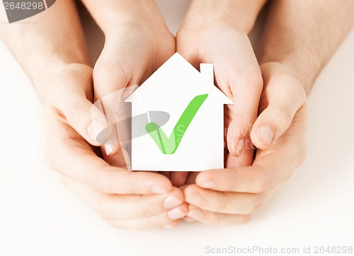 Image of hands holding house with check mark