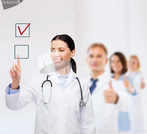 Image of smiling female doctor pointing checkbox