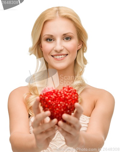 Image of smiling woman giving small red heart