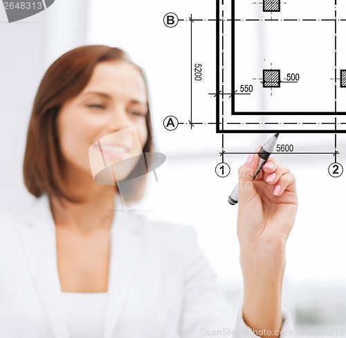 Image of female architect drawing blueprint