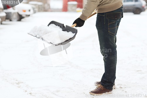 Image of closeup of man shoveling snow from driveway