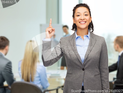 Image of smiling businesswoman with her finger up at office