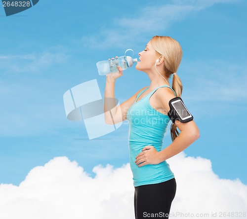 Image of sporty woman running with smartphone and earphones
